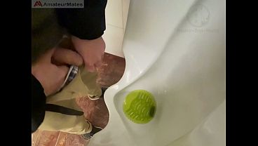 Amateur redhead guy caught pissing in a public toilet's urinal - he then quickly plays with his cock before leaving