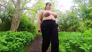 A busty milf topless in a park