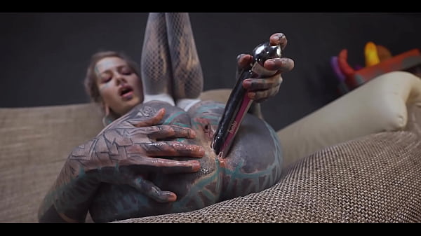 Tattoo slut sinks a thick metal toy deep into her hole