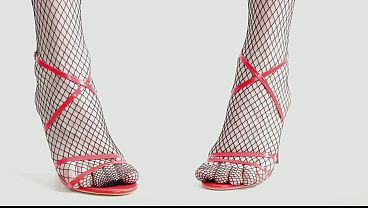 Feet In Black Fishnet Pantyhose Tights And Red High Heels