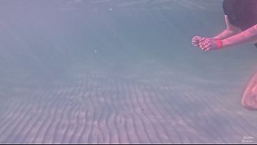 Hosszú lábú amatőr lány relaxáló víz alatti úszása