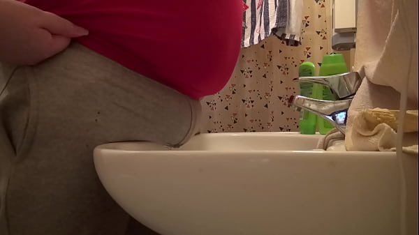 peeing through gray pants over the sink