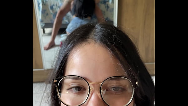 Busty brunette nerd giving a deep blowjob to Wellington Prado's big dick with her back to the mirror in denim shorts