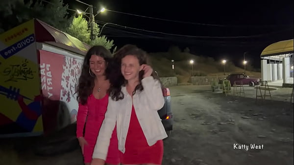 Two girls pissing in public near the car