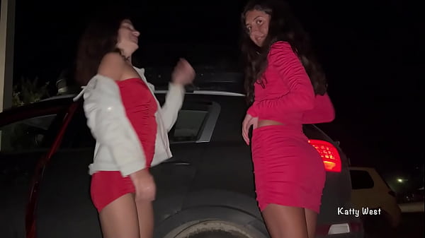 Two girls pissing in public near the car