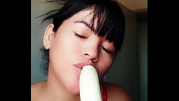 Young girl teasing by sucking and eating banana, very excited with a naughty face wanting a cock in her mouth