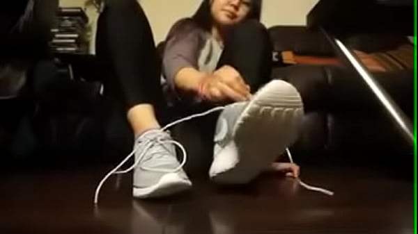 Asian girl takes off her tennis shoes and socks