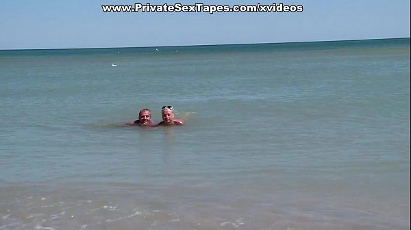 A couple of nudism lovers hardly pairing off on the sand