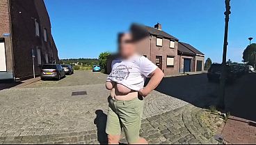 A busty milf walking in the street braless