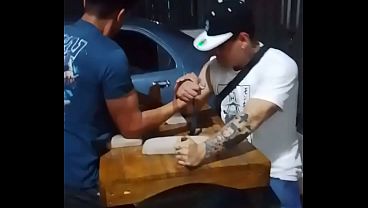 2 hombres amarrados manoseandose encima de la mesa