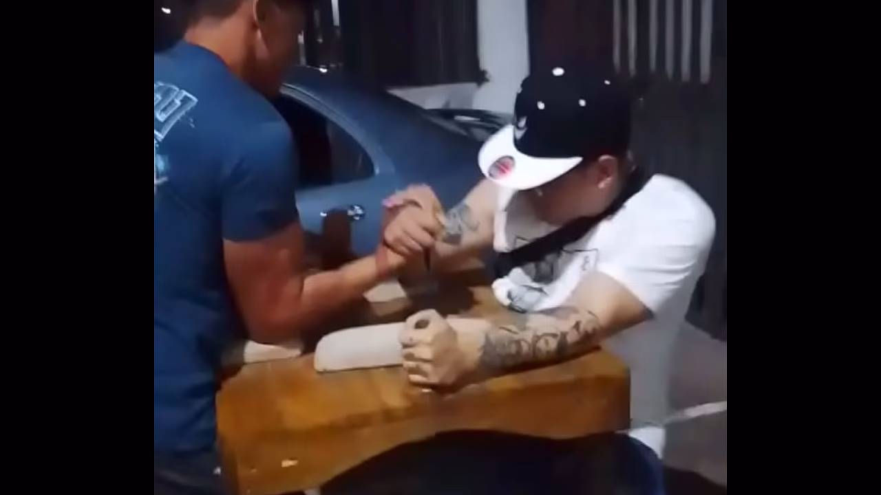 2 hombres amarrados manoseandose encima de la mesa