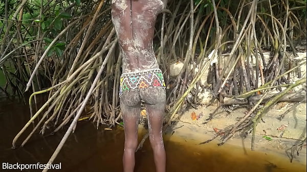 Indigeneous naked woman making a camp fire