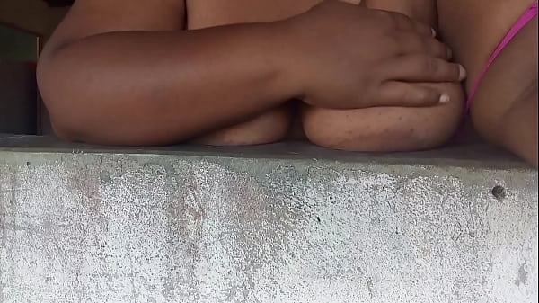 Naughty believer in the window showing her breasts to the men on the street