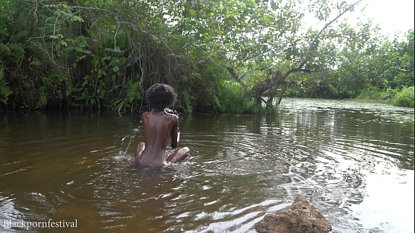 Attractive African village girl bathing in the river