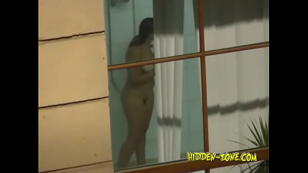A girl washes in the shower, and we see her through the window