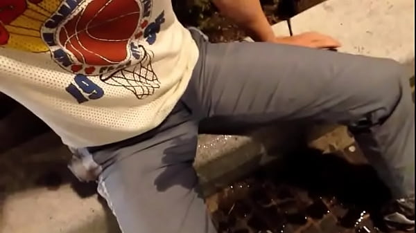 Selfpissing next to busy shopping street