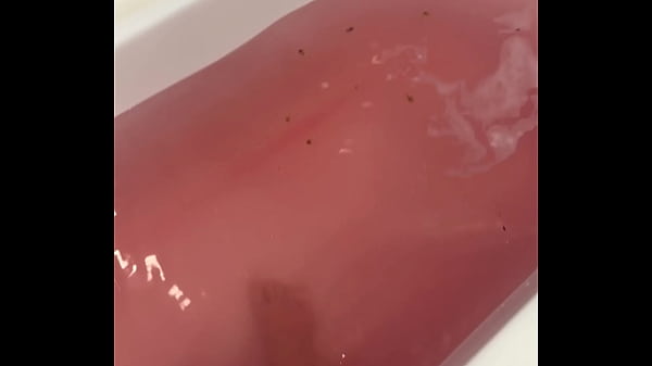 Close-up of a girl peeing in the bath water. The girl farts underwater and plays with her small tits