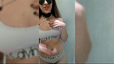 白いランジェリーを着てシャワーを浴びるセクシーな若い女性