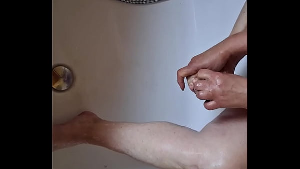Dreckige Füße in der Badewanne waschen