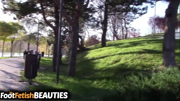 Barefoot brunette shows off her feet in public in the park