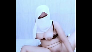 Indonesian hijab-wearing woman pees with a bottle until she urinates