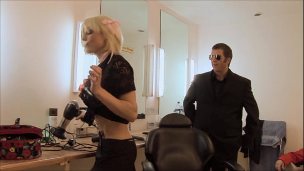 A pair of sexy blondes with big boobs, wearing provocative thigh-high fishnet stockings...