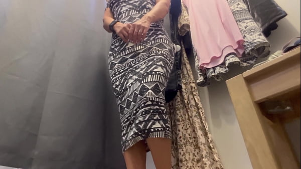 An excited girl with big tits tries on clothes