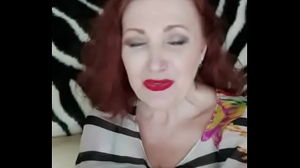Red-haired lady shows her breasts in a white-black blouse