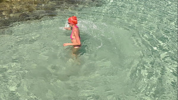 美しい湾でピンクのビキニ