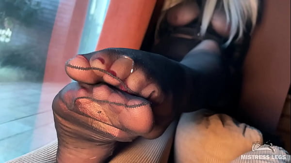 Goddess foot tease in black torn nylons opposite a panoramic window