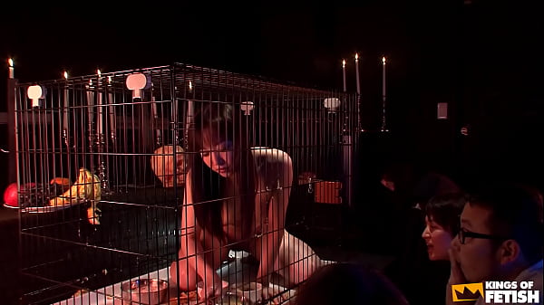 Japanese babe in cage eats and pisses in front of more guys