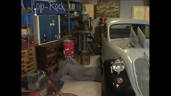 Experienced brunette in fishnets gives a deepthroat blowjob to a young mechanic in the garage