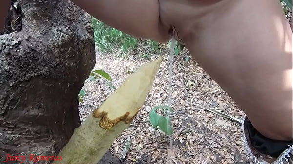 Perverted slut squirts piss from wooden stake in forest