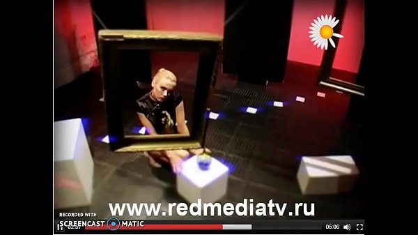 Svetlana Demeschenko looking through a picture frame and stripping