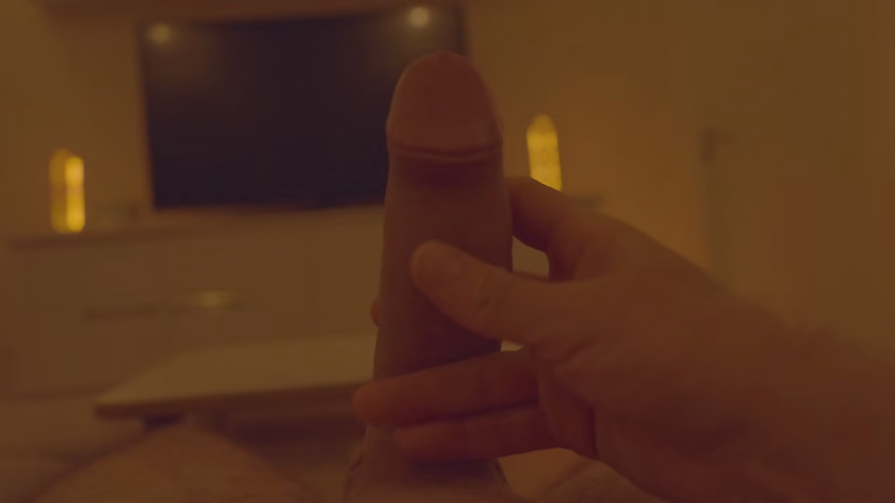 Massage of a large penis in front of a large TV